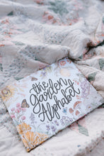 Load image into Gallery viewer, Floral notebook with 'the Garden Alphabet' text on a textured fabric background