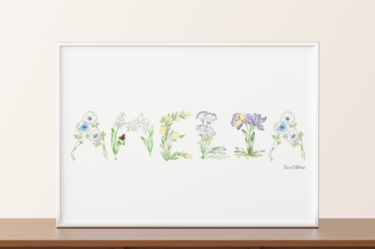 Framed artwork of watercolor flowers spelling out "Amelia" on a white background