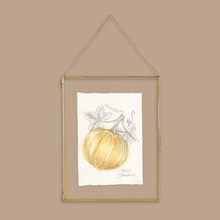 Load image into Gallery viewer, A framed art print featuring a watercolor pumpkin illustration on a white sheet of paper, enclosed in a thin gold metal frame with a hanging chain, set against a solid beige background.
