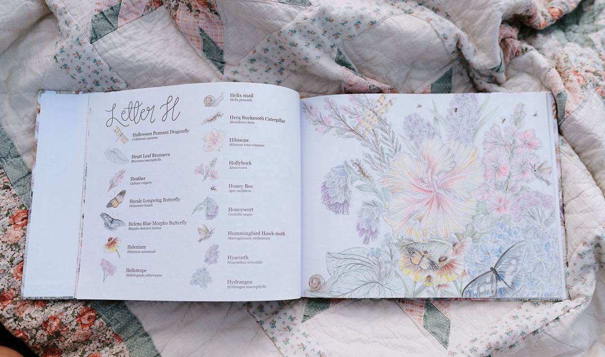 Open book with illustrations of flowers and text on a floral fabric background