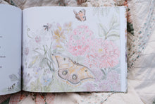 Load image into Gallery viewer, Open book with illustrations of butterflies and flowers on a textured fabric background
